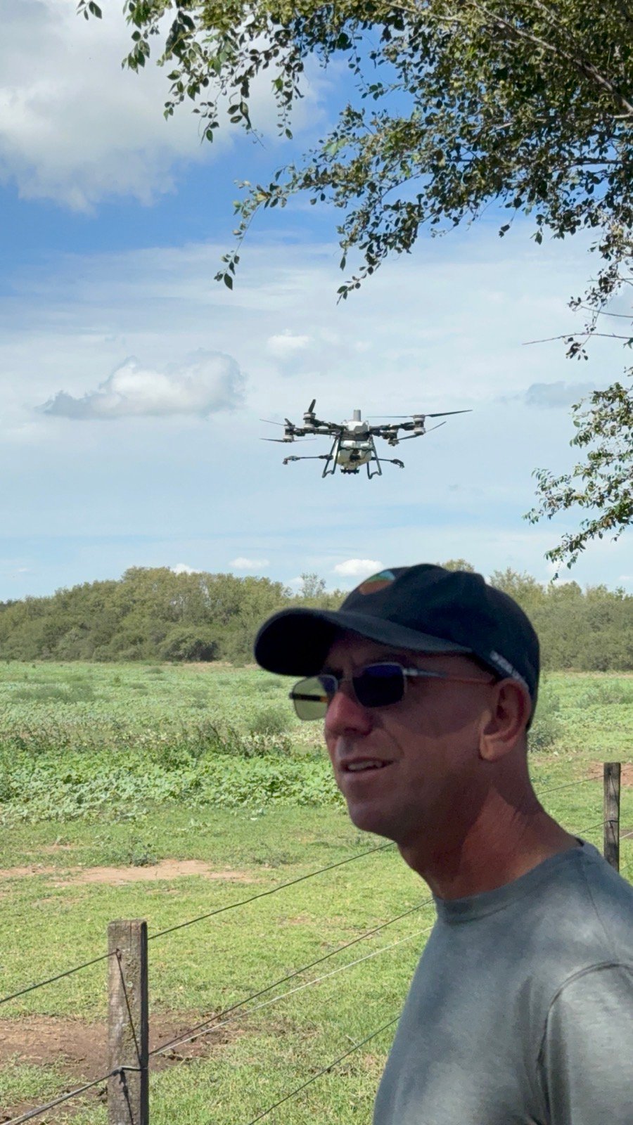 Rodrigo Becerra observando un dron agrícola pulverizando un cultivo